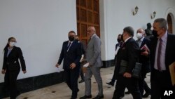 ARCHIVO - El presidente de la Asamblea Nacional, Jorge Rodríguez, centro, acompañado por miembros de la comisión para el diálogo, llega para hablar con la prensa en la Asamblea Nacional en Caracas, Venezuela, en marzo de 2022. 