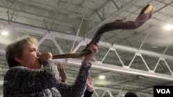Laura Brown hace sonar su shofar en el segundo día del evento ReAwaken America Tour. 