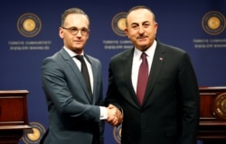 Turkish Foreign Minister Mevlut Cavusoglu and his German counterpart Heiko Maas, left, shake hands, in Ankara, Turkey, Oct. 26, 2019.