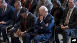 President Joe Biden, with from left, House Minority Leader Hakeem Jeffries and House Speaker Mike Johnson, pray and listen during the National Prayer Breakfast, Feb. 1, 2024, at the Capitol in Washington.