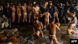 Men cleanse their bodies in a river during the Sominsai Festival at Kokuseki-ji Temple in Oshu, Iwate Prefecture, Japan, Feb. 17, 2024. 