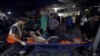 A wounded Palestinian is carried into the al-Shifa hospital following Israeli airstrikes on Gaza City, Oct. 26, 2023.