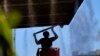 Un hombre trabaja afuera bajo los rociadores, el jueves 13 de julio de 2023 en el centro de Phoenix, Arizona, que está siendo azotado con temperaturas de más de 40 grados Celsius y advertencias de calor excesivo. (Foto AP/Matt York)