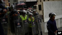 Elementos de la Policía Nacional Bolivariana enfrenta una marcha en la sede de la Oficina Nacional de Presupuesto (ONAPRE) en Caracas, Venezuela, el martes 23 de agosto de 2022.