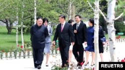 ARCHIVO - El líder norcoreano Kim Jong Un camina con el presidente chino Xi Jinping durante la visita de Xi a Pyongyang, Corea del Norte, en esta imagen publicada por la Agencia Central de Noticias de Corea del Norte (KCNA, por sus siglas en inglés), el 21 de junio de 2019.