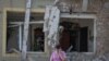 Seorang perempuan menelpon dari lokasi serangan pesawat tak berawak Rusia di pinggiran Lviv, Ukraina, di tengah serangan Rusia ke Ukraina, 19 Juni 2024. (REUTERS/Roman Baluk)