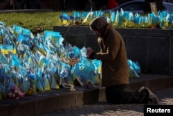 Un hombre visita un monumento improvisado formado por banderas ucranianas con los nombres de los miembros del servicio caídos, en la Plaza de la Independencia, en medio del ataque de Rusia a Ucrania, en Kiev, Ucrania, el 7 de noviembre de 2023. REUTERS/Gleb Garanich