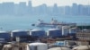 FILE - A China Ocean Shipping Company (COSCO) vessel is seen near oil tanks at the China National Petroleum Corporation (CNPC)'s Dalian Petrochemical Corp in Dalian, Liaoning province, China, October 15, 2019.
