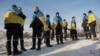 Newly-swapped Ukrainian prisoners of war, with Ukrainian national flags draped around their shoulders, are seen after an exchange for Russian POWs at an unspecified location on the Ukraine-Russia border, Jan. 31, 2024. 