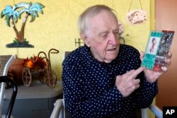 Tom Henschel holds up tickets to quarterback Tom Brady's first and last Super Bowl games during an interview at his home, in Tampa, Florida, Jan. 25, 2024.