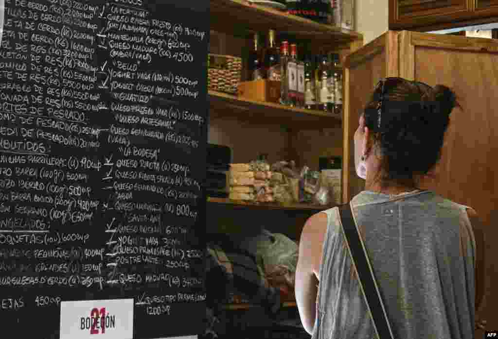 Una mujer observa los precios de productos que se ofertan en el &quot;Bodegón 21&quot;, un pequeño negocio en La Habana, Cuba, el 5 de junio de 2023.