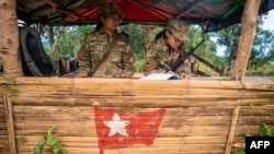 Esta foto tomada el 9 de diciembre de 2023 muestra a mujeres miembros de las Fuerzas de Defensa del Pueblo de Mandalay (MDY-PDF) haciendo guardia en su campamento base en el bosque cerca del municipio de Namhsan en el estado de Shan, en el norte de Myanmar.