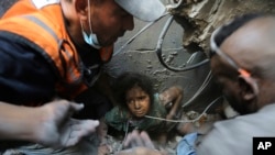 Palestinos intentan sacar a una niña de los escombros de un edificio destruido por los ataques aéreos israelíes en el campo de refugiados de Jabaliya, al norte de la Franja de Gaza, el miércoles 1 de noviembre de 2023.