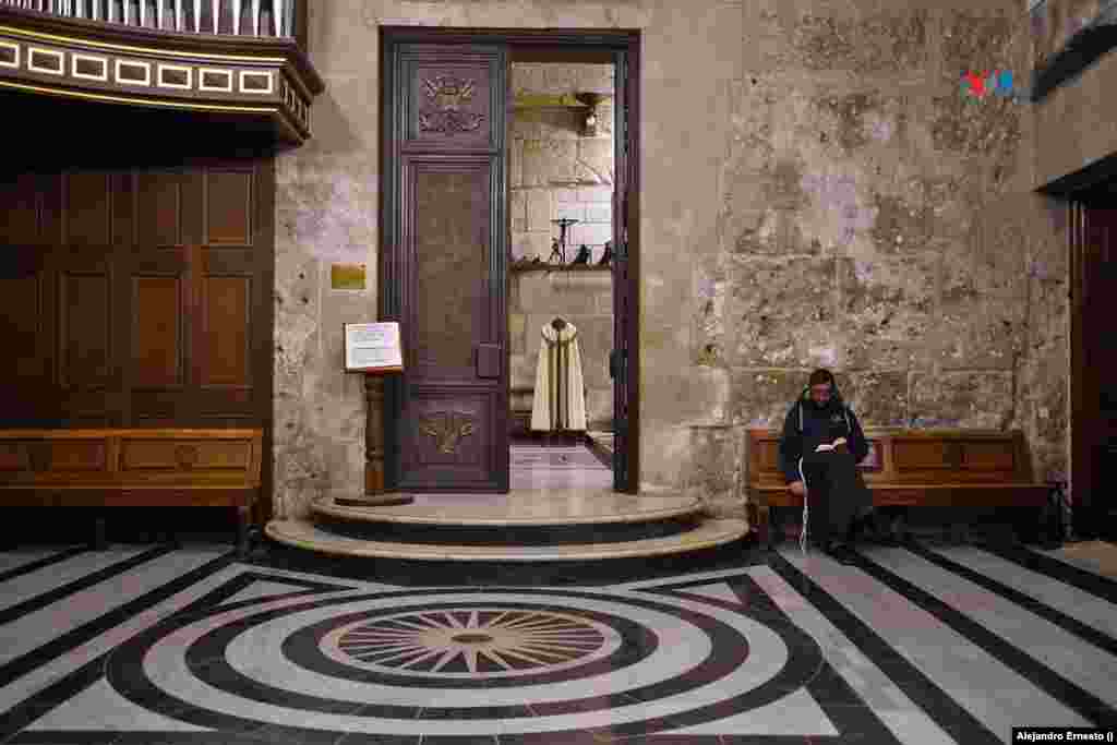 Un religioso lee sentado en un banco junto a una pequeña capilla del Santo Sepulcro de Jerusalén, el lugar más sagrado para los cristianos.