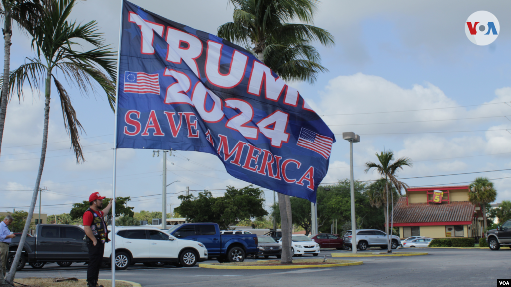 Una bandera de grandes dimensiones es sostenida por un manifestante pro Trump en Palm Beach, Florida, el 3 de abril de 2023. 