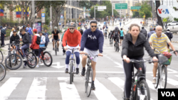 Un grupo de personas disfrutando de la ciclovía en Bogotá, un espacio que abre la ciudad los domingos y días feriados con actividades deportivas al aire libre en las calles y parques. [Foto: Federico Buelvas, VOA]