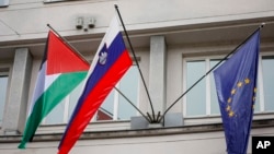 A Palestinian flag flies next to a Slovenian, center, and a European Union flag, right, at the government building in Ljubljana, Slovenia, Thursday, May 30, 2024.