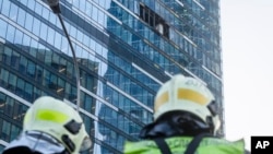 Los bomberos observan un edificio dañado en el distrito comercial "Ciudad de Moscú" después de un ataque con drones en Moscú, Rusia, la madrugada del martes 1 de agosto de 2023.