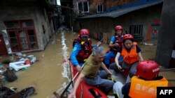 Tim evakuasi membantu sejumlah warga di area yang terdampak banjir di Nanping, China, pada 16 Juni 2024. (Foto: CNS/AFP)