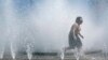 Un niño juega en una fuente para refrescarse en el centro de Portland, Oregón, EEUU, el 12 de mayo de 2023.