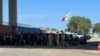 ARCHIVO - Autoridades fronterizas agrupan a migrantes irregulares que se entregaron para ser procesados tras cruzar a Eagle Pass, Texas, el 29 de septiembre de 2023. (Salomé Ramírez, VOA)