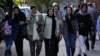 FILE - Iranian women, some without wearing their mandatory headscarves, walk in Tehran on Sept. 9, 2023. Iran has arrested four people, accusing them of giving a foreign-based broadcaster video of an argument between a Shiite cleric and a woman not wearing a headscarf.