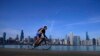 A cyclist pedals around Lake Michigan near the Adler Planetarium, Feb. 26, 2024, in Chicago. 