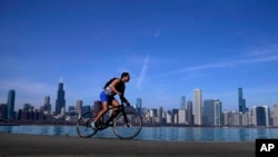 A cyclist pedals around Lake Michigan near the Adler Planetarium, Feb. 26, 2024, in Chicago. 
