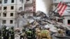 Foto yang dirilis oleh Gubernur wilayah Belgorod Vyacheslav Gladkov di media sosial pada 12 Mei 2024, menunjukkan pekerja darurat Rusia di luar blok apartemen yang sebagian runtuh setelah serangan rudal Ukraina, di kota Belgorod.