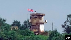 FILE - Seorang tentara Korea Utara berdiri di pos jaga militer Korea Utara saat bendera Korea Utara berkibar tertiup angin, terlihat dari Paju, Korea Selatan, 24 Juli 2024.