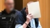 A defendant arrives in a courtroom where nine men were to be tried for treason, attempted murder and plotting a coup, in Stuttgart, Germany, April 29, 2024. Trial begins May 21 for nine others suspected in the plot to overthrow Germany's democracy.