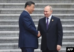 El presidente de Rusia, Vladimir Putin, y el presidente de China, Xi Jinping, asistieron a una ceremonia oficial de bienvenida frente al Gran Salón del Pueblo en la Plaza de Tiananmen en Pekín el 16 de mayo de 2024. (Sergei Bobylyov/Sputnik vía AFP)