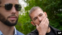 FILE - Andrew Tate, right, and his brother Tristan, left, leave the Bucharest Tribunal, in Bucharest, Romania, Apr. 21, 2023. 