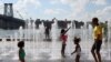 ARCHIVO - La gente se refresca en una fuente de agua en Domino Park mientras una ola de calor azota la región en Brooklyn, Nueva York, EEUU, el 8 de agosto de 2022.