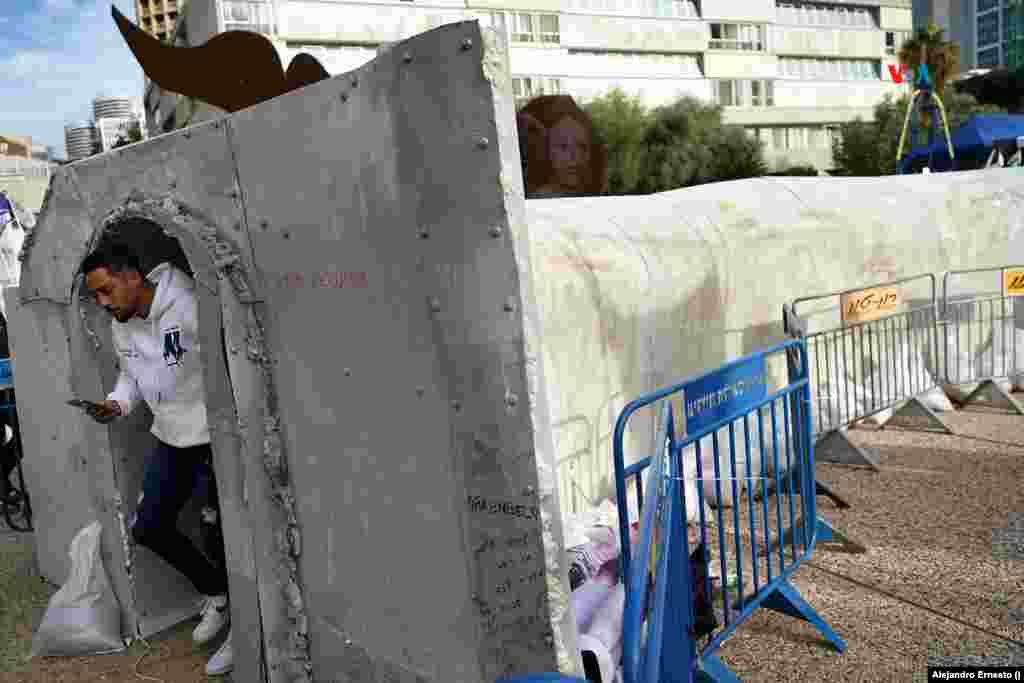Un hombre sale por uno de los extremos de la réplica de un túnel de Hamás emplazada en Tel Aviv.
