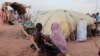 FILE - Fayrouz, 10, a Sudanese girl who fled the conflict in Geneina in Sudan's Darfur region, gives a bath to her brother Awad, 6, outside their makeshift shelter in Adre, Chad, Aug. 5, 2023. 