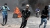 FILE — Protesters run for cover from tear gas fired by police during a protest against insecurity in Port-au-Prince, Haiti, Aug. 7, 2023. 