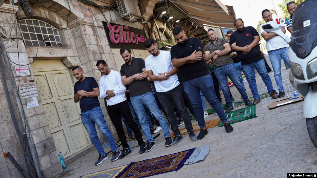 Hombres rezan en las calles del barrio de mayoría musulmana en Jerusalén, fuertemente militarizada este 13 de octubre de 2023, cuando exlíderes de Hamás han llamado a un &quot;día de indignación palestina&quot; en todo el mundo.&nbsp;