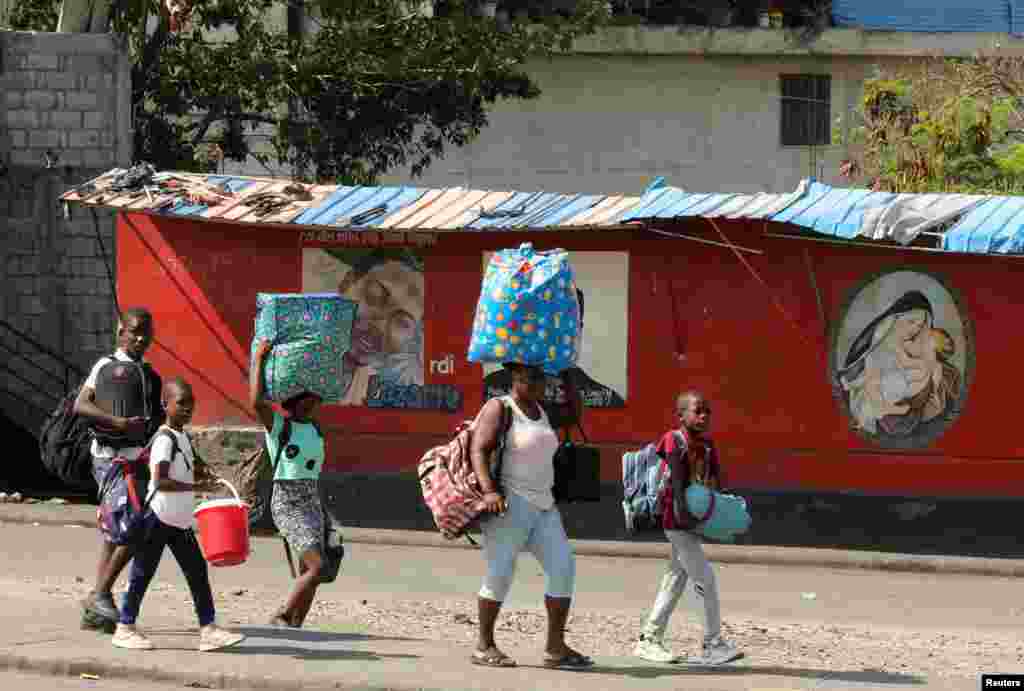Haitianos huyen de sus hogares con sus pertenencias para escapar de la violencia de las pandillas.&nbsp;Puerto Príncipe, Haití, el 6 de marzo de 2024.