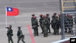 资料照片：一名士兵在台湾桃园举行的一年一度的汉光军事演习举着中华民国国旗。(2023年7月26日)