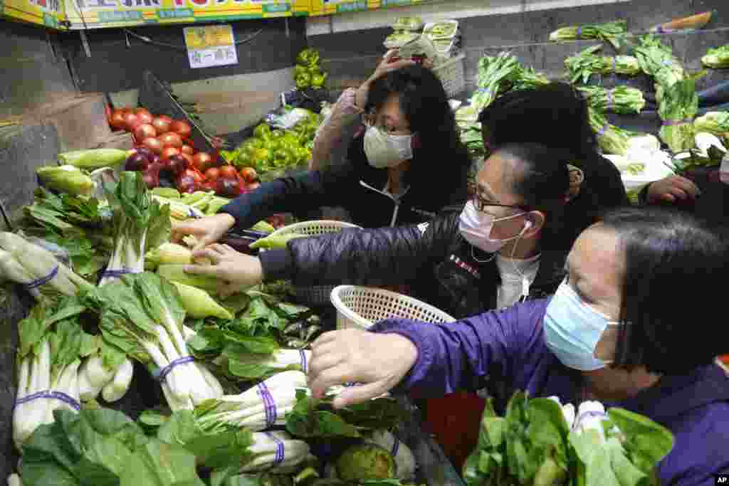 Alrededor del mundo se sintieron las restricciones. En un mercado en Hong Kong, el miércoles 9 de febrero de 2022, personas usando mascarillas eligen vegetales. Las autoridades de Hong Kong habían anunciado entonces restricciones de distanciamiento social más estrictas en la ciudad.&nbsp;