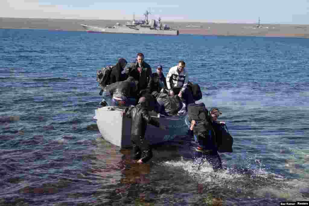 Los miembros de la tripulación del buque de guerra ucraniano Konstantin Olshansky, que fue bloqueado por buques de guerra rusos, llegan a tierra después de abandonar su barco el 23 de marzo. Posteriormente, el barco fue incautado e incorporado a la Armada rusa. Con la península de Crimea firmemente bajo control ruso, el 7 de abril el escenario estaba preparado para la guerra cuando grupos prorrusos en Donetsk y Luhansk irrumpieron en oficinas gubernamentales y se apoderaron de armamento. Kiev respondió anunciando el inicio de una operación &quot;contraterrorista&quot;.