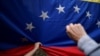 ARCHIVO - Los seguidores de la líder opositora venezolana María Corina Machado sostienen una bandera nacional durante su discurso mientras recorre el país, en San Antonio de los Altos, Estado Miranda, Venezuela, 17 de abril de 2024. 