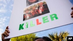 Tracy Kinsinger holds up a sign as Alex Murdaugh walks into the Colleton County Courthouse for sentencing in Walterboro, South Carolina, March 3, 2023.