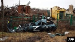Un vehículo destruido marcado con el signo "Z" que representa la agresión de Rusia contra Ucrania y los edificios demolidos como resultado de los bombardeos se ven en la aldea de Kamenka, en la región de Kharkiv en Ucrania, el 26 de febrero de 2023.