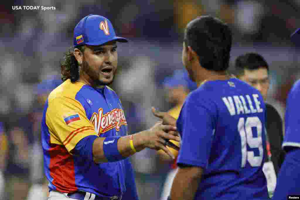 El venezolano Eugenio Suárez (7) le da la mano al nicaragüense Norlando Valle (19) después del partido.