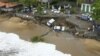 Esta imagen proporcionada por el gobierno de Sao Paulo muestra vehículos de caídos de una zona desmoronada junto a la playa en Sao Sebastiao, al este de Sao Paulo, Brasil, el domingo 19 de febrero de 2023, tras una fuerte tormenta en la zona
