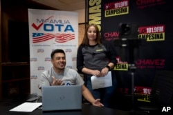 Los miembros del personal Michael Ruiz, izquierda, y Marisol Moraga participan en un evento de banco telefónico en La Campesina, una cadena de radio en español en Phoenix, el 20 de marzo de 2024.
