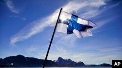 FILE - Finland's flag flies aboard the Finnish icebreaker MSV Nordica as it arrives at Nuuk, Greenland, July 29, 2017. Finland has again come out on top of an international index that ranks nations by how happy they are as places to live.