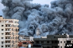 Una columna de humo se eleva sobre los edificios de la ciudad de Gaza el 7 de octubre de 2023 durante un ataque aéreo israelí que alcanzó el edificio de la Torre Palestina.